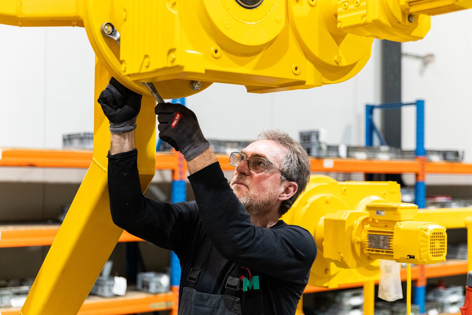Monteur van Microtechniek voert reparatie en onderhoud uit aan gele industriële machine voor technische installaties en machinebouw in de staalindustrie